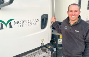 More Clean of Texas Employee standing next to a More Clean Sweeper Truck.