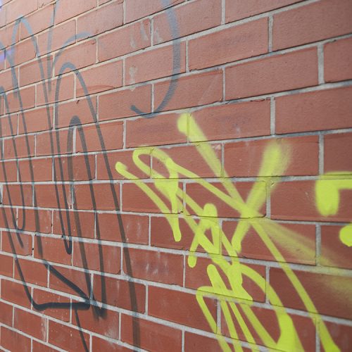 Unsightly graffiti visible on a brick wall